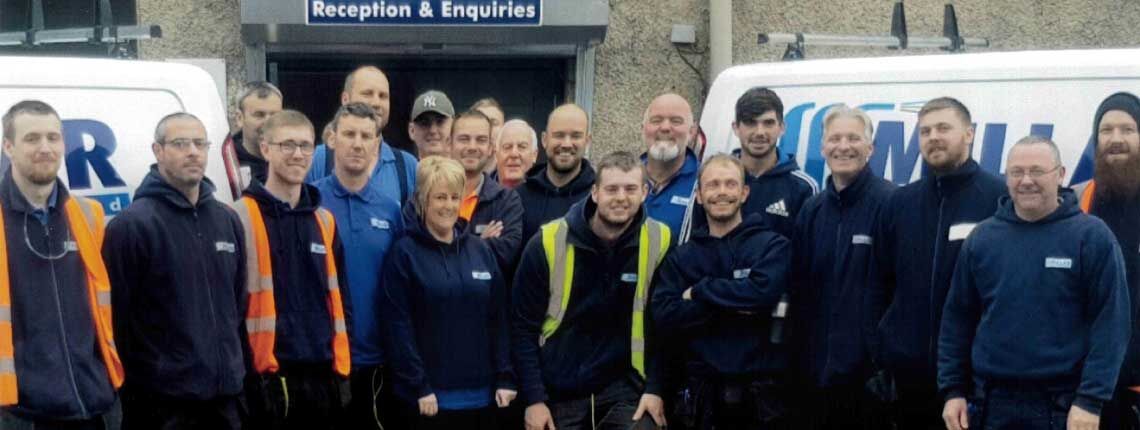 The Millar Electrics team in front of the company vans